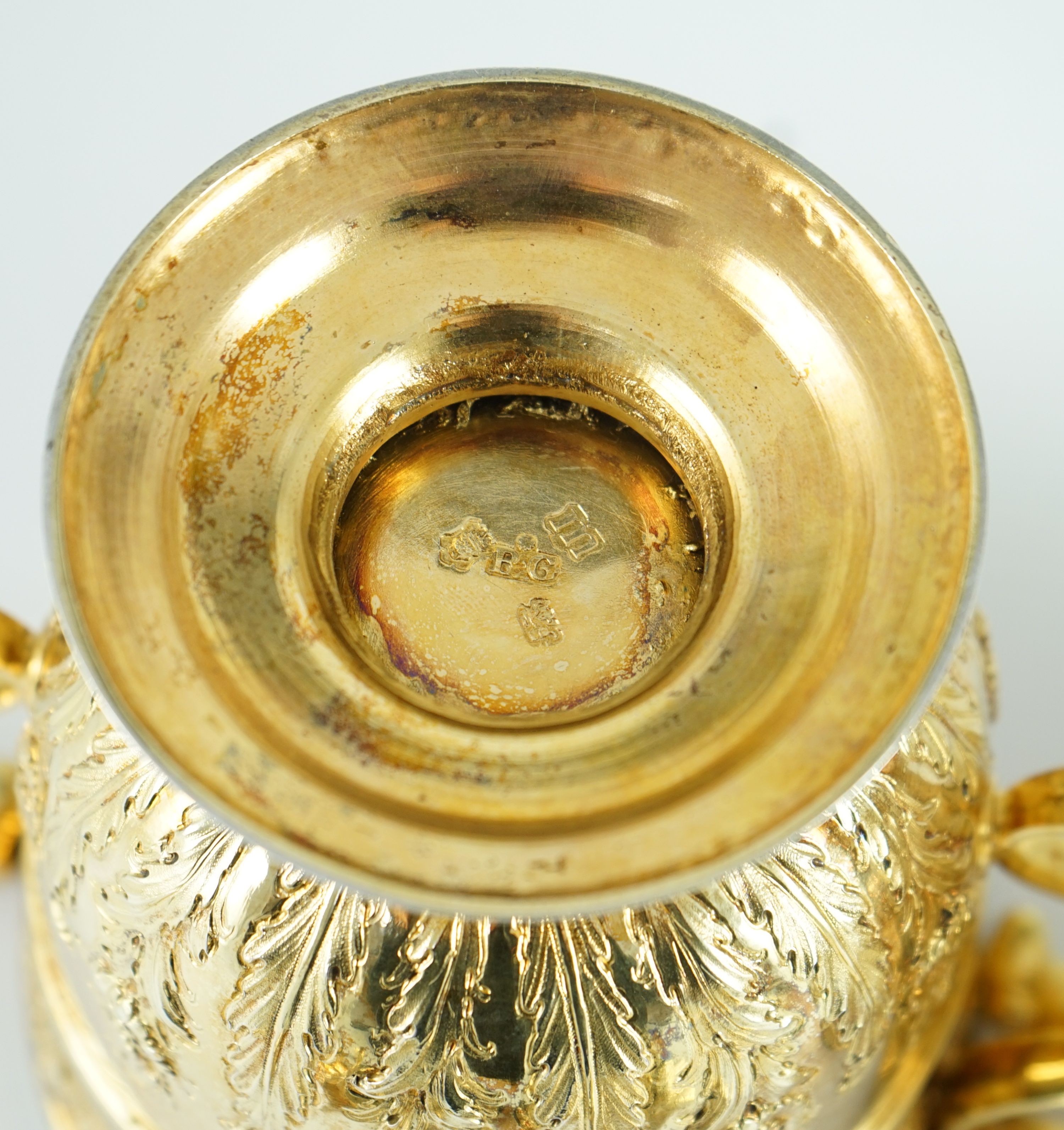 A good pair of George II embossed silver gilt two handled pedestal cups and covers, by Benjamin Gignac